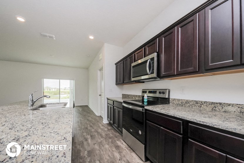 a kitchen with marble counter tops and dark wood cabinets