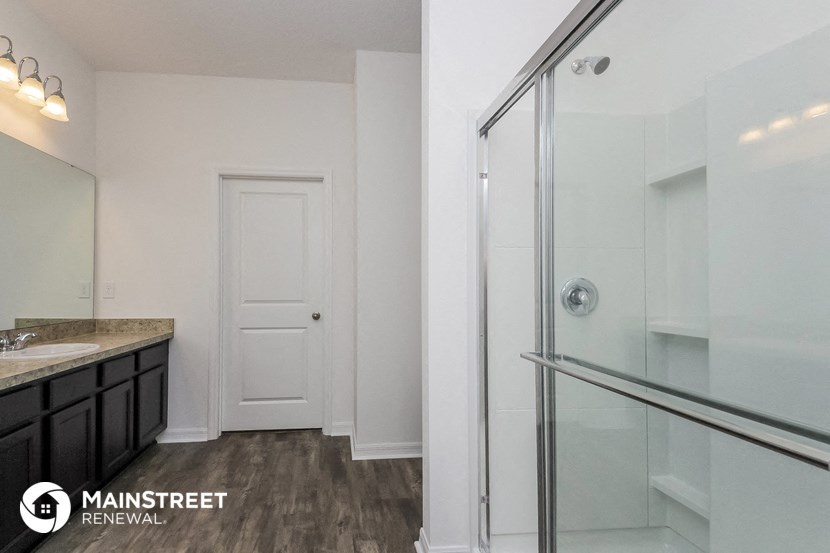 a bathroom with a glass shower and a sink