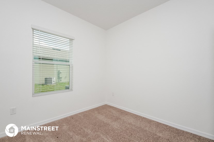 the upstairs bedroom with carpet and a window