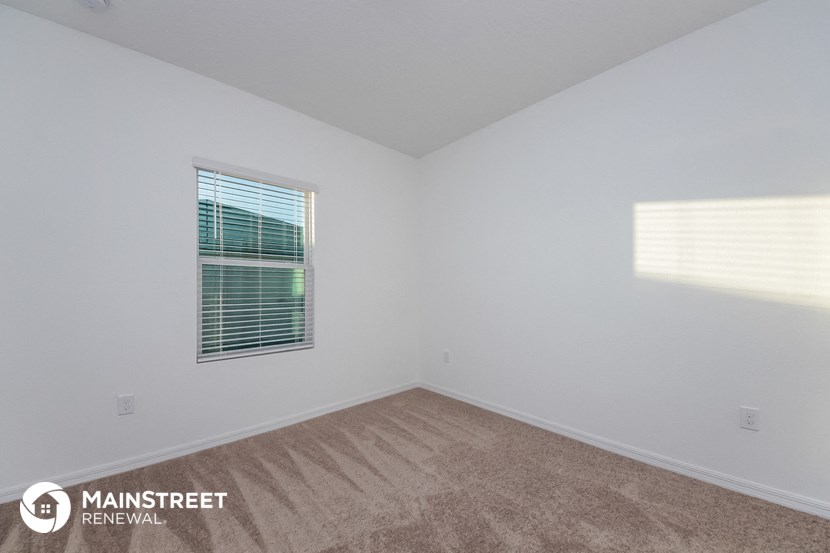 the upstairs bedroom with carpet and window