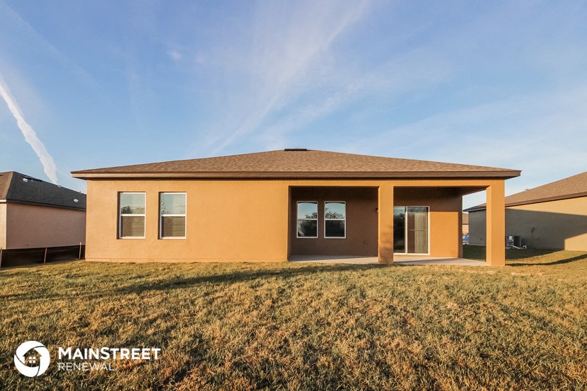 a single story home with a brown roof and a grass yard