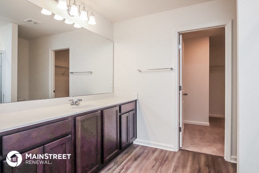 a bathroom with a large mirror and a long counter with a sink