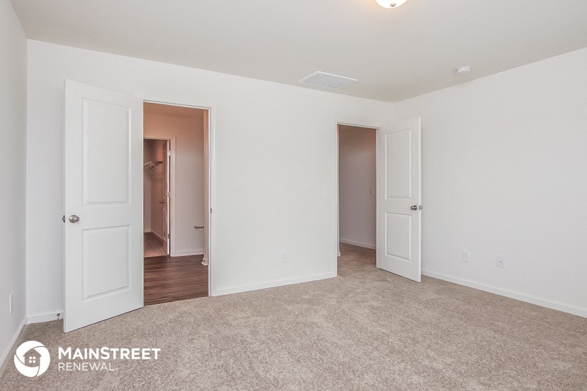 a bedroom with two doors and a carpeted floor