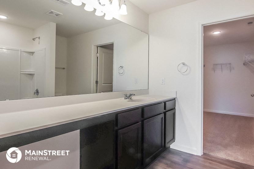 the master bathroom has a large mirror and a large sink