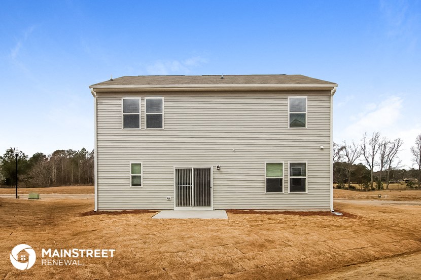 the front of a small house with a dirt lot