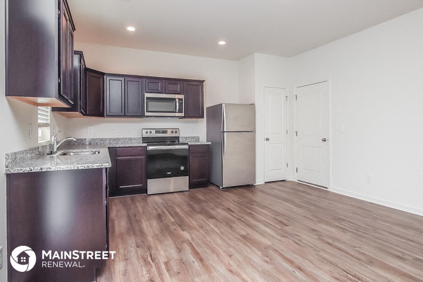 a kitchen with stainless steel appliances and a wooden floor