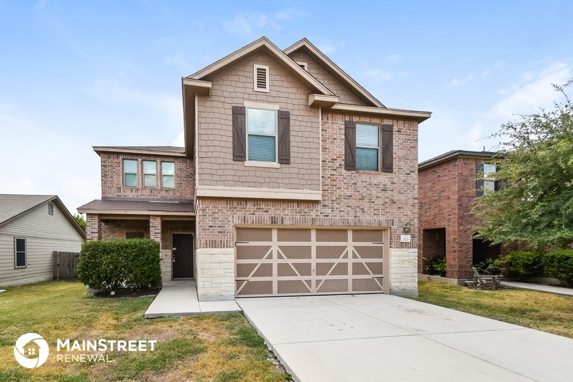 a tan brick house with a white garage door