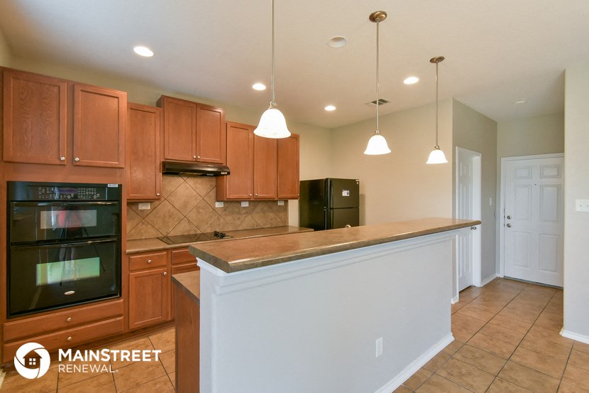 a large kitchen with a counter top and wooden cabinets