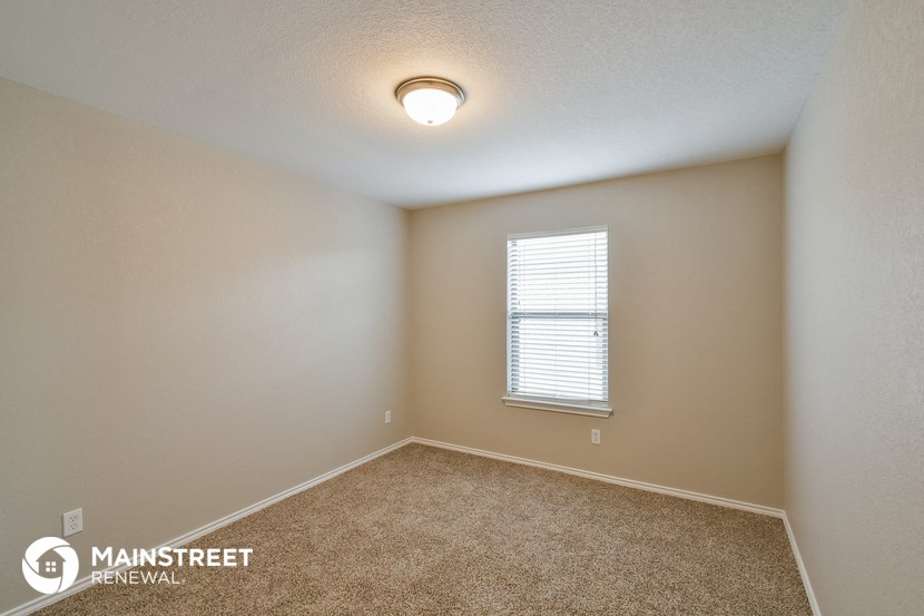 the living room of a home with carpet and a window