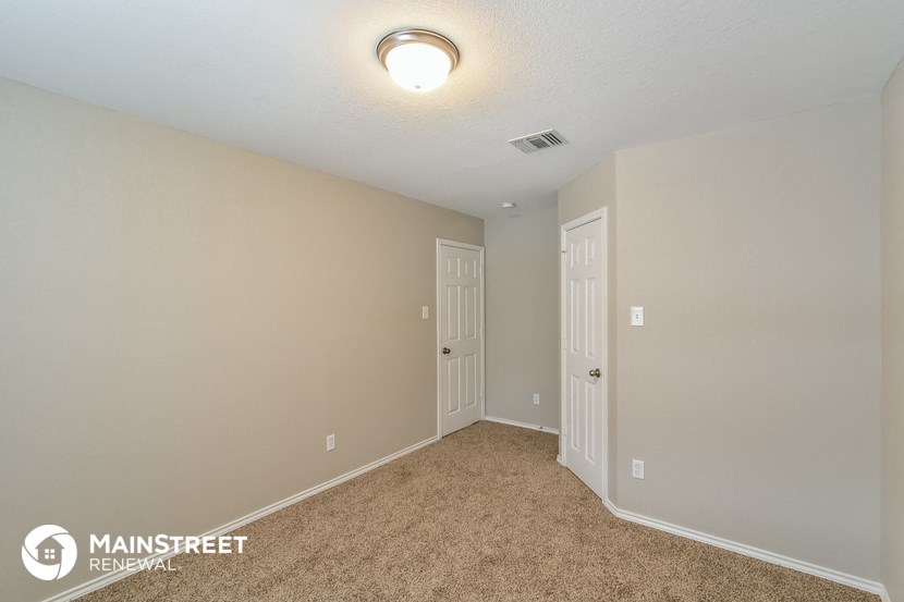 a bedroom with a carpeted floor and a door to a closet