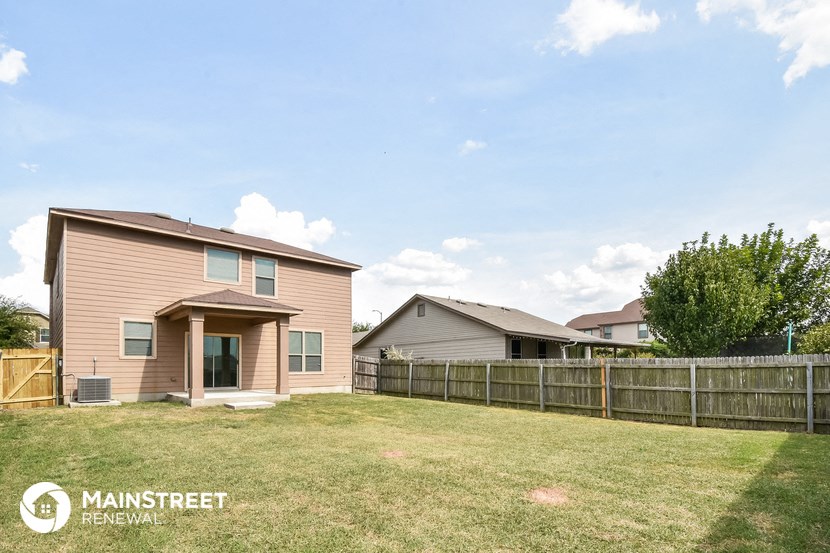 a backyard with a house and a wooden fence