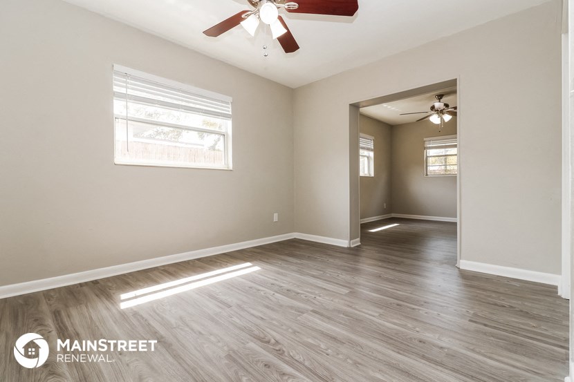 the living room and dining room of an empty house