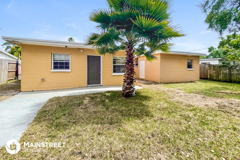 a yellow house with a palm tree in front of it