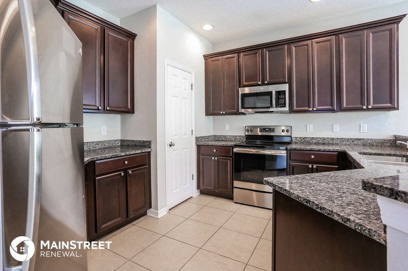 a kitchen with wooden cabinets and granite counter tops and stainless steel appliances