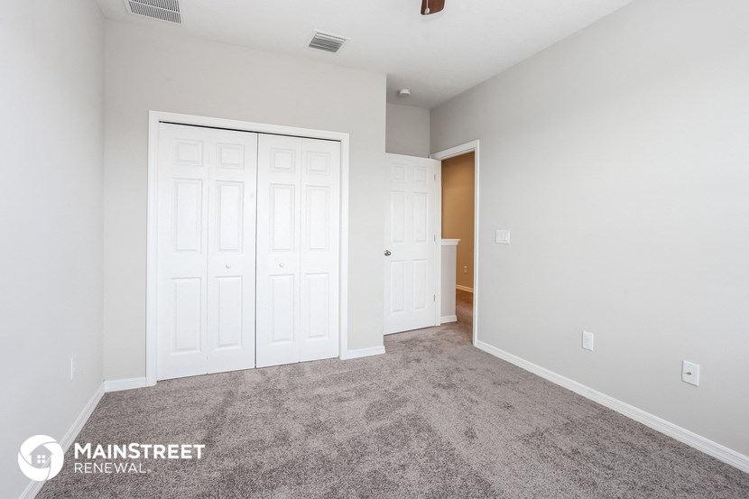 the living room of a new home with white doors and carpet