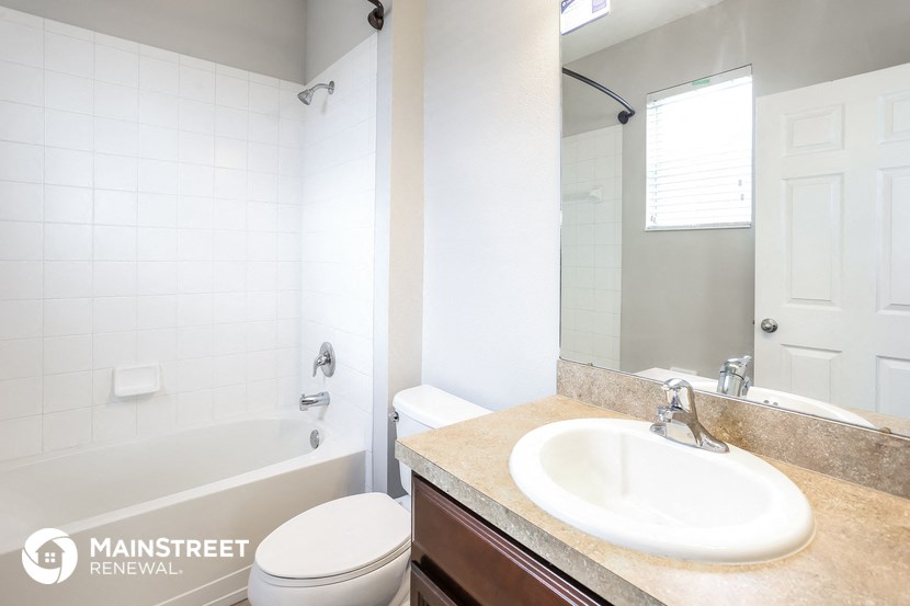 a bathroom with a sink toilet and tub and a mirror