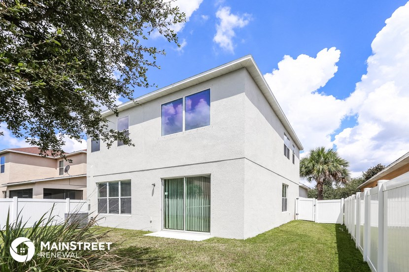 a white house with a lawn and a fence