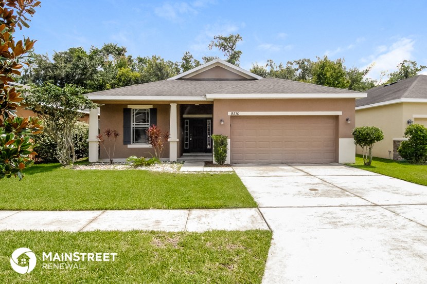 a home with a lawn and a garage door