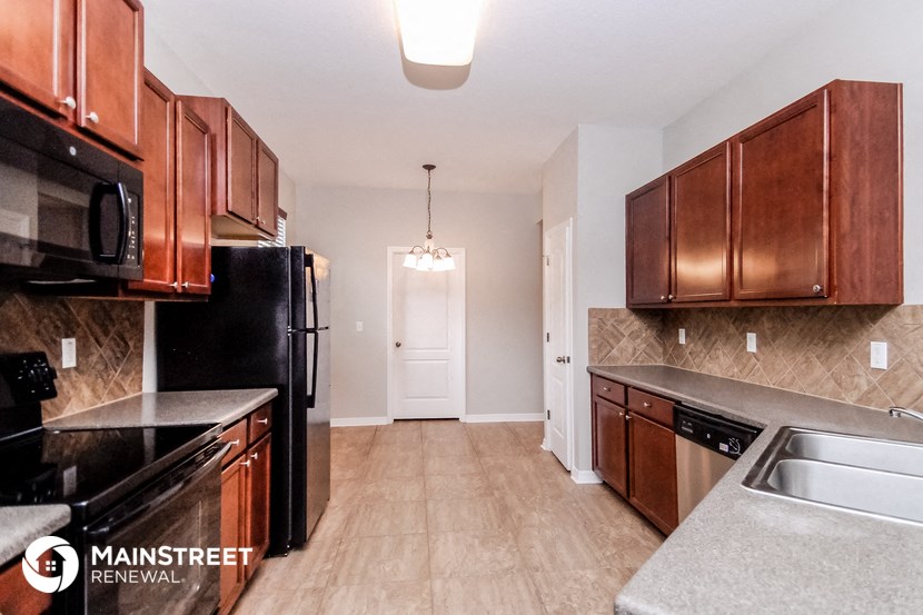 an empty kitchen with black appliances and wood cabinets