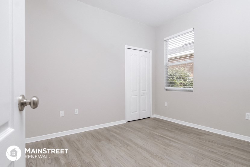 the upstairs bedroom with a door to the closet and a window