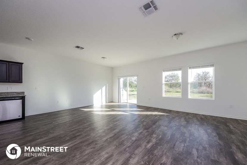 an empty living room with white walls and wood floors