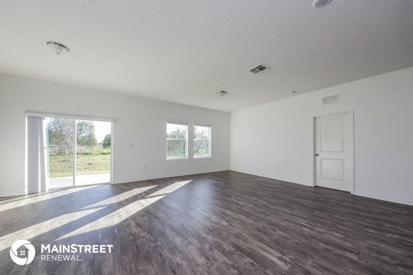 an empty living room with white walls and wood floors