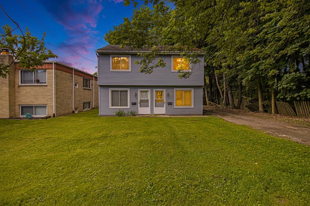 a white house with a yard and a brick house