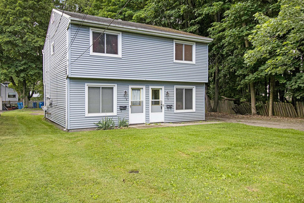 a blue house with a yard in front of it