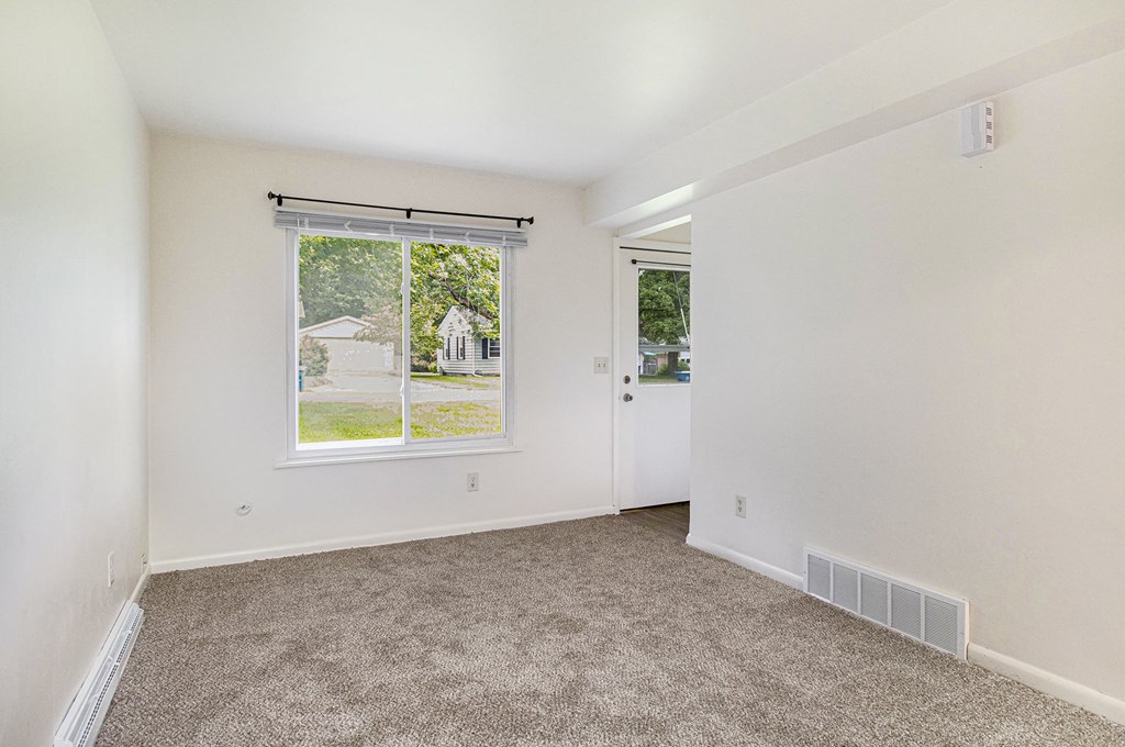 an empty room with carpet and a window