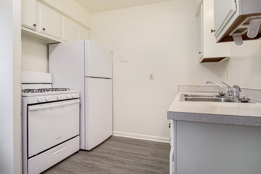 a kitchen with white appliances and a sink and a refrigerator