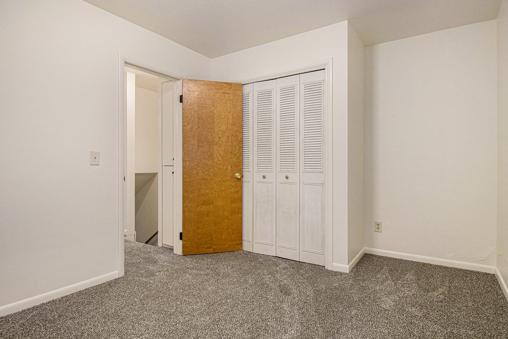 a bedroom with two closets and a door to a bathroom