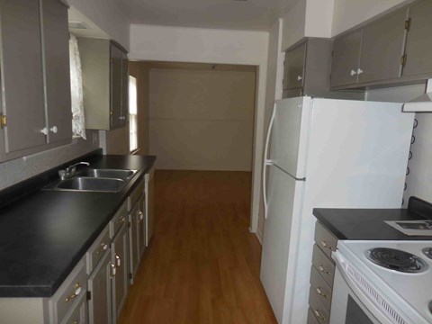 a kitchen with a stove and a refrigerator and a sink