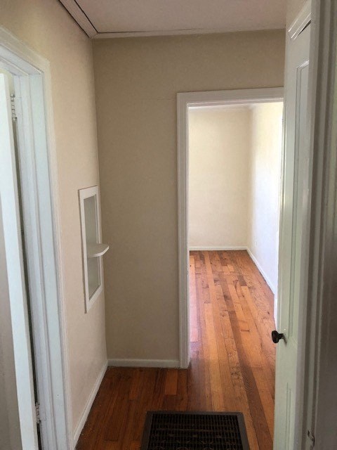 a hallway with a wood floor and a white door