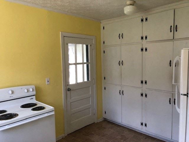 a kitchen with a white stove and white cabinets