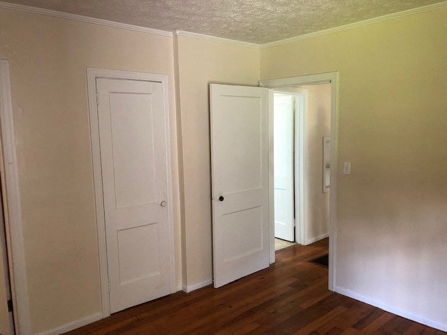 an empty room with three doors and a wood floor