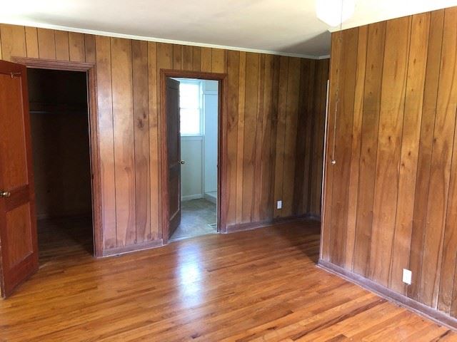 an empty room with wooden walls and a wood floor