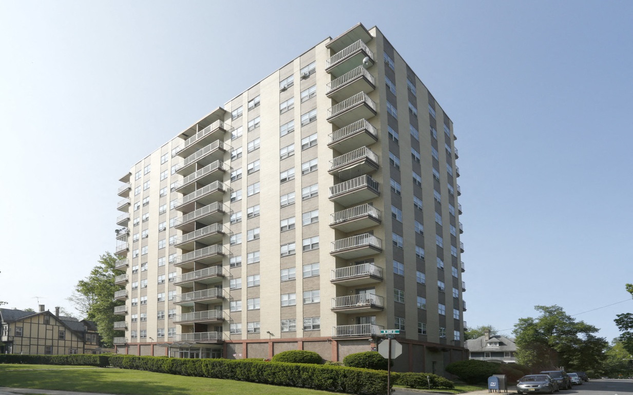 A tall residential building with balconies on each floor.