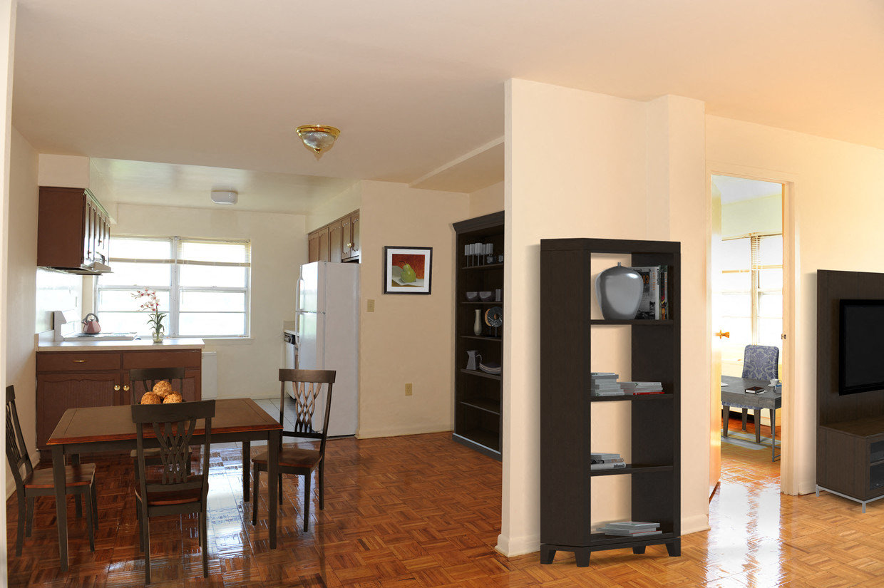 A living room with a wooden floor and a dining table with chairs.