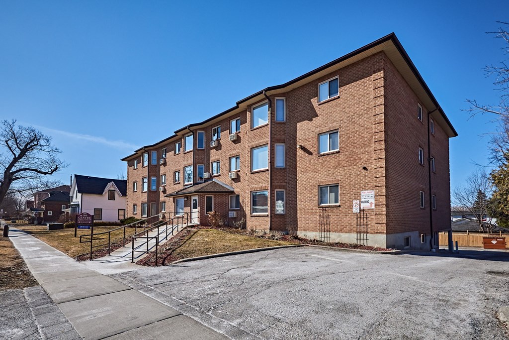 a brick apartment building with stairs and a driveway