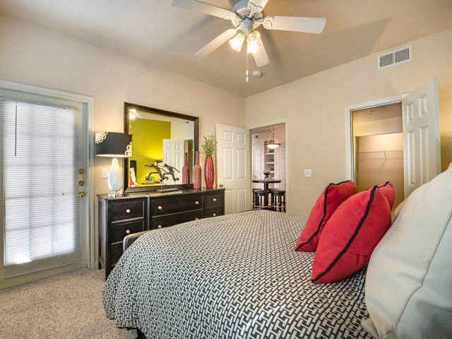 a bedroom with a large bed and a ceiling fan