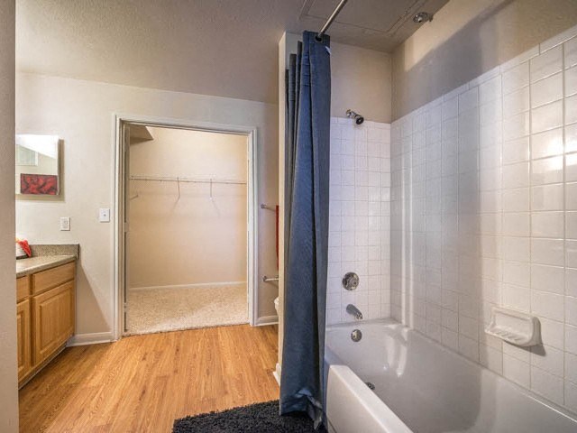 a bathroom with a tub and a shower and a sink