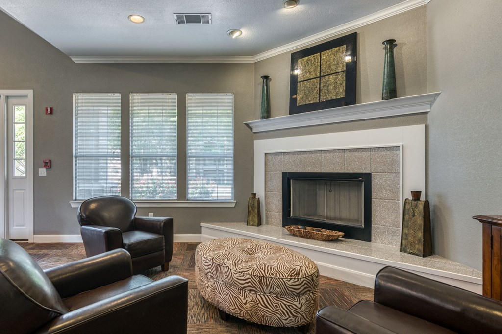 a living room with a fireplace and leather furniture