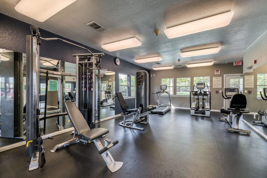 a gym with weights and cardio equipment and lights on the ceiling