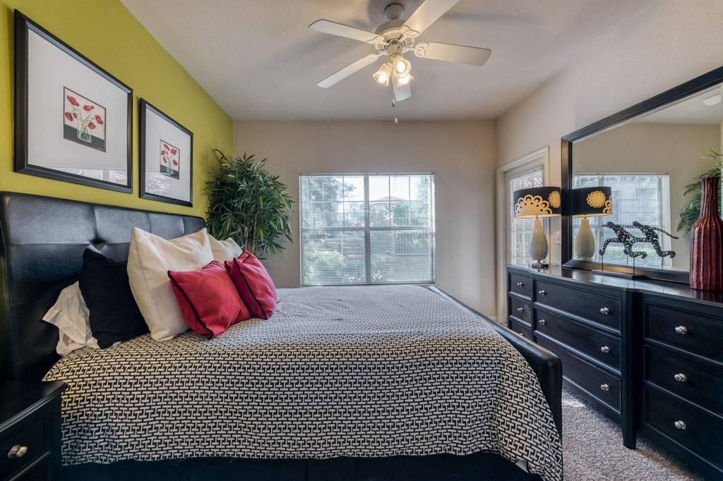 a bedroom with a bed and a ceiling fan