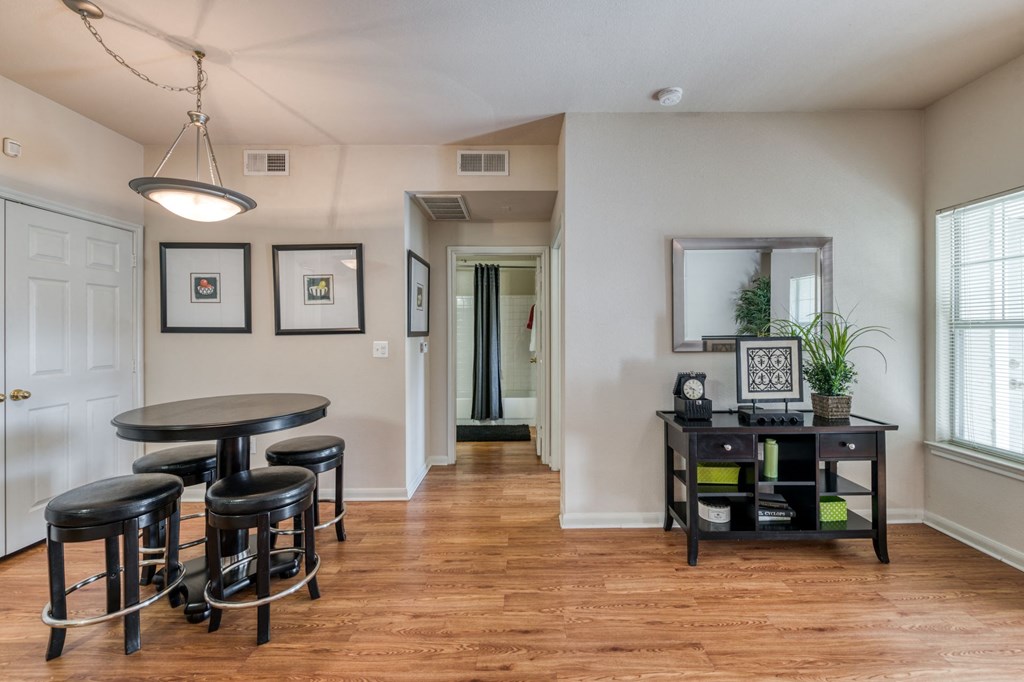 an empty living room with a dining room table and chairs