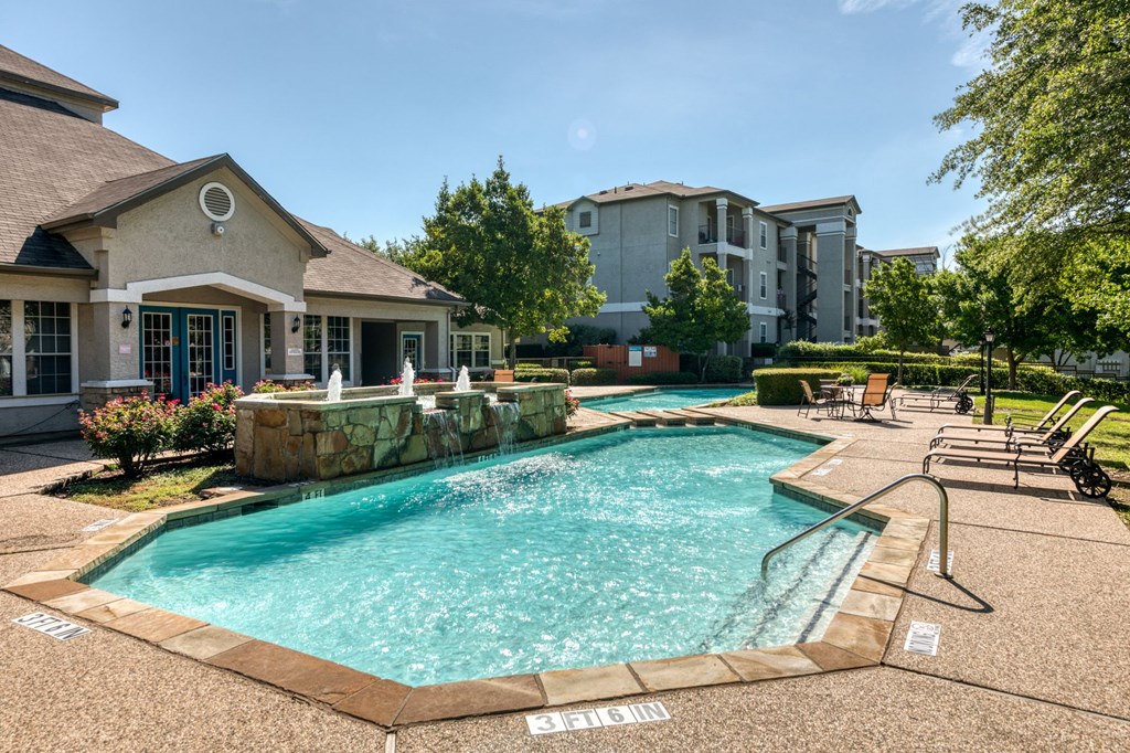 a swimming pool with a house and a resort style pool