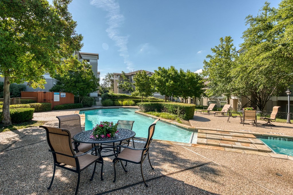 a patio with a table and chairs next to a swimming pool