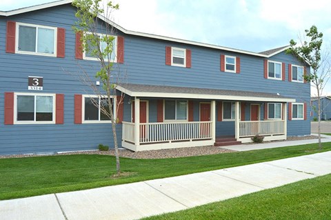 a blue house with a porch and a sidewalk