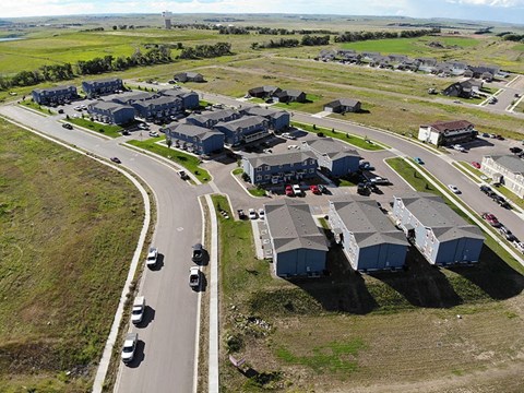 an aerial view of a neighborhood of houses and cars on a road