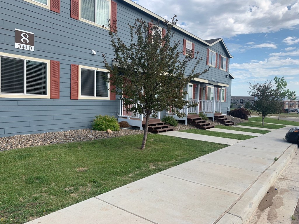 a blue house with a sidewalk in front of it